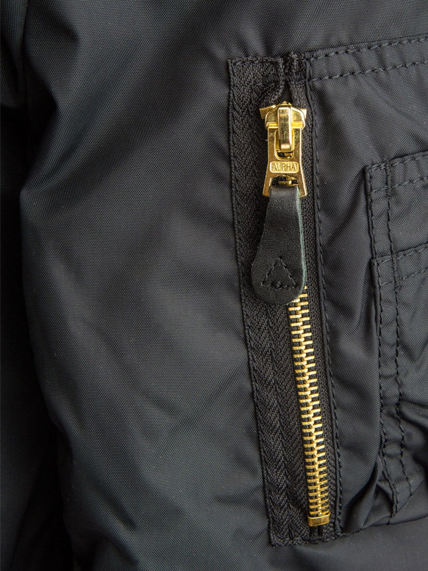 MA-1 Skymaster Bomber Jacket by Alpha Industries, gold zipper with black leather pull tab.