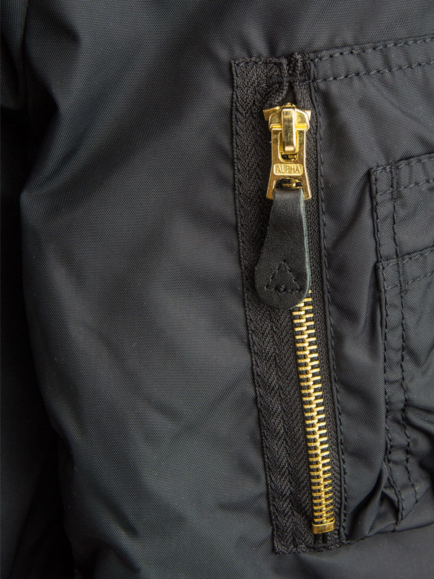MA-1 Skymaster Bomber Jacket by Alpha Industries, gold zipper with black leather pull tab.