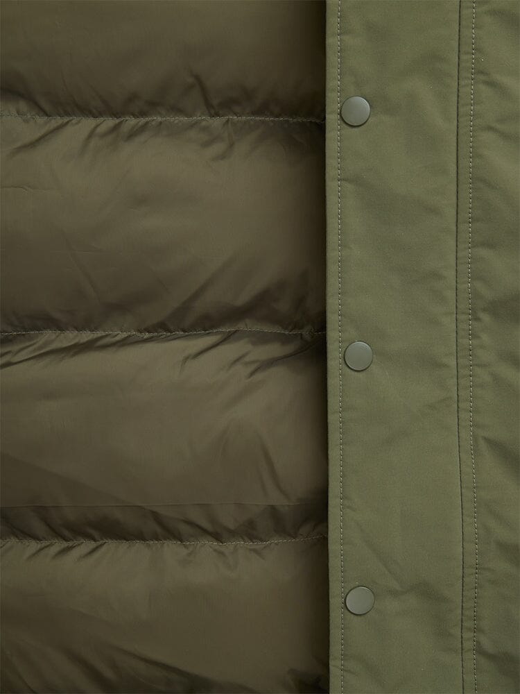Close-up of an olive green padded N-2B Altitude Parka from Alpha Industries, featuring button snaps on the right edge and a water-resistant finish.