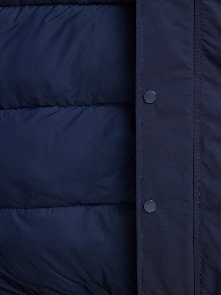 Close-up of a blue padded N-2B Altitude Parka from Alpha Industries, featuring button snaps on the right edge and a water-resistant finish.