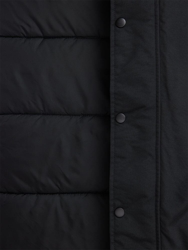A close-up of the N-3B Altitude Mod Parka by Alpha Industries showcases its dark, quilted fabric with snap button closures on the right side, echoing a mod parka design.