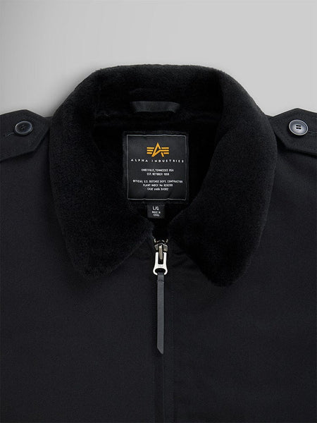 Close-up of a 1940s B-10 Bomber Jacket in black, showcasing a fuzzy collar and full-zip front that evokes the classic flight jacket style. The label proudly reads Alpha Industries.