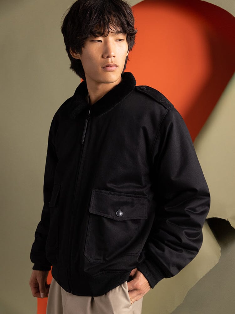 An individual wearing the 1940s B-10 Bomber Jacket by Alpha Industries in black.