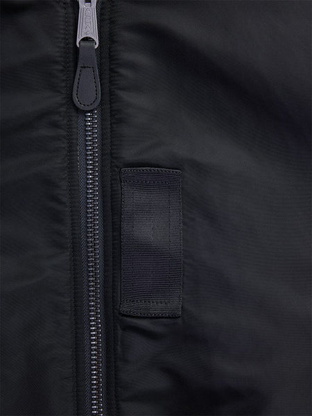 Close-up of the 1960s MA-1 Bomber Jacket in black by Alpha Industries, featuring a silver zipper and a small black fabric loop.