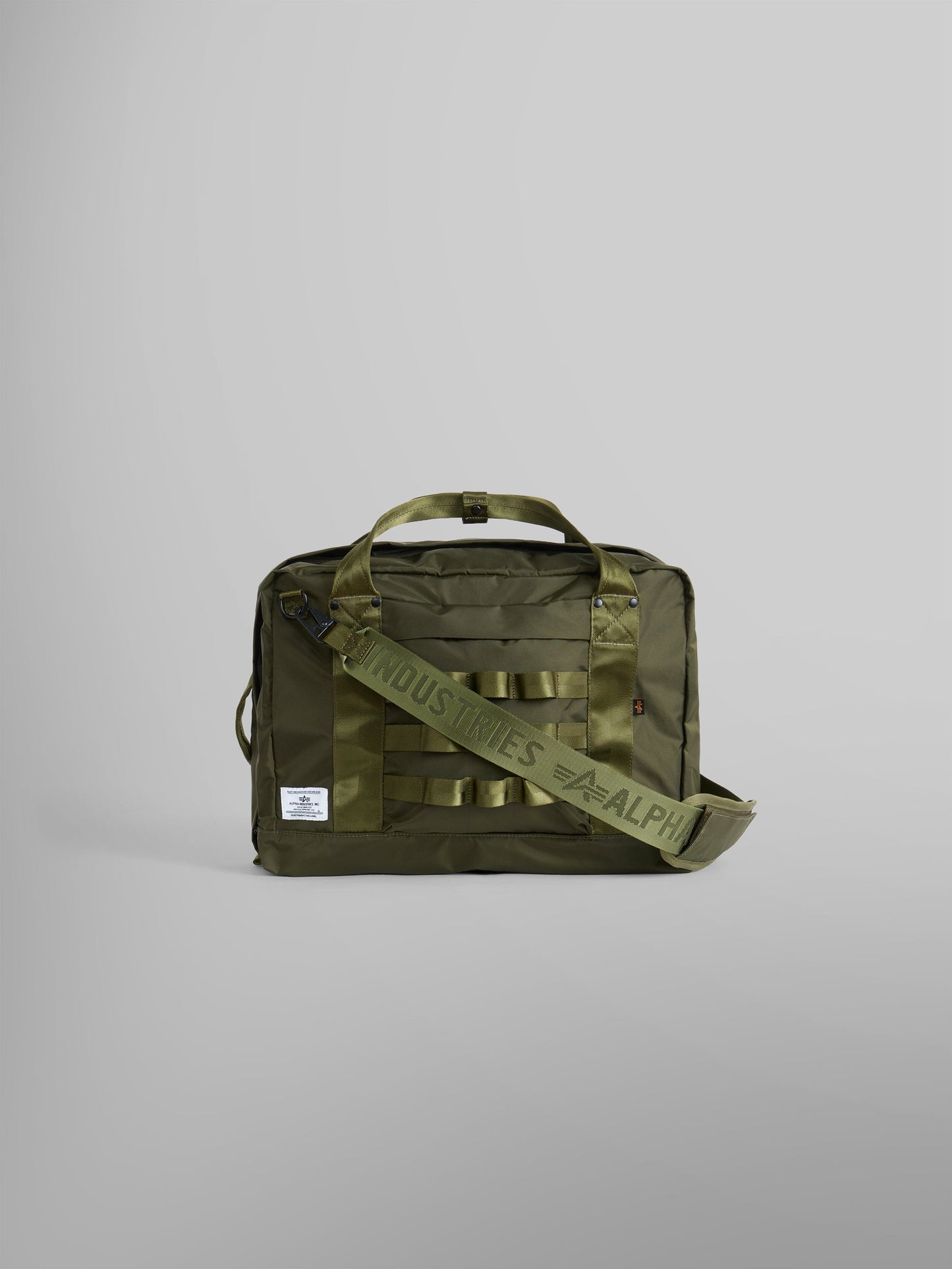 24 Hr Bag by Alpha Industries in dark green nylon with dual handles, front label, and adjustable shoulder strap.