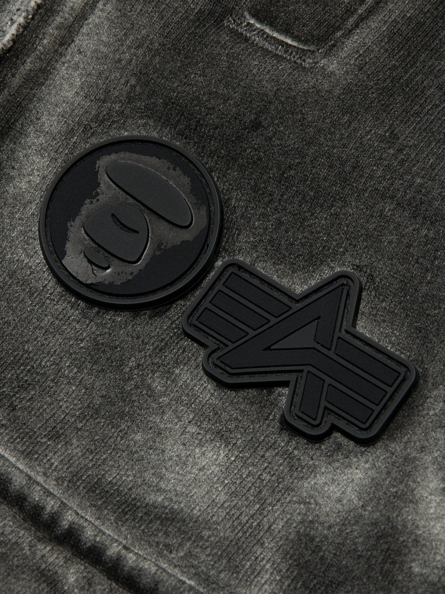Aape X Alpha Army Sweatpant by Alpha Industries, gray fabric with two black rubber patches, one featuring a stylized ape face and the other a geometric A.