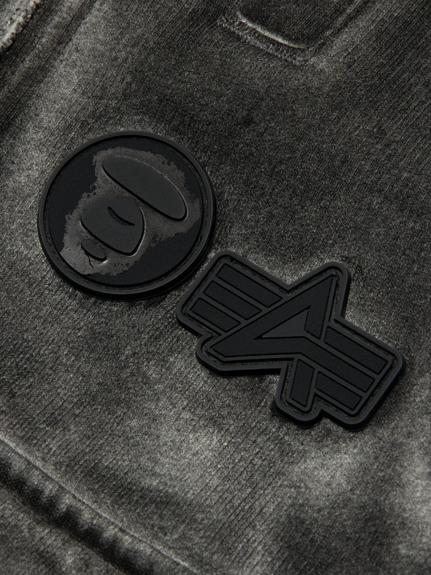 Aape X Alpha Army Sweatpant by Alpha Industries, gray fabric with two black rubber patches, one featuring a stylized ape face and the other a geometric A.