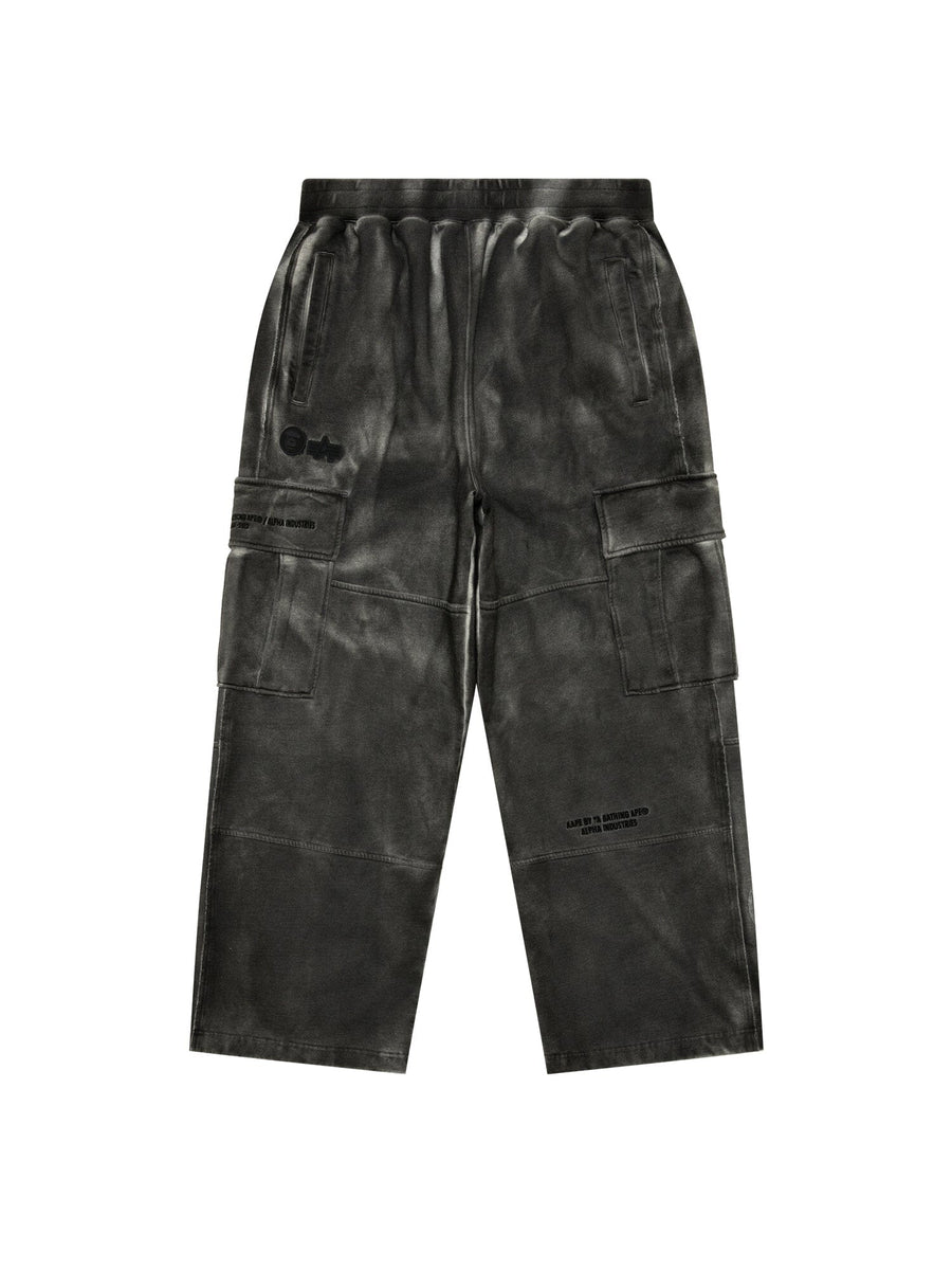 Aape X Alpha Army Sweatpant by Alpha Industries in black with wide legs, multiple pockets, and subtle printed text.