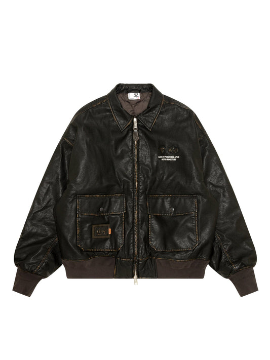 Aape X Alpha Pu Leather Quilted Jacket by Alpha Industries, brown, MA-1 bomber style, military details, front zipper, two large pockets, ribbed cuffs and hem, visible seam stitching.