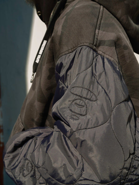 Aape X Alpha Reversible Padded MA-1 Quilted Jacket by Alpha Industries, dark camouflage with shiny quilted sleeves.