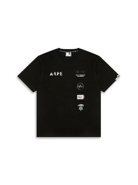 The AAPE X Alpha Somewhere In Universe Tee by Alpha Industries is a black T-shirt with white and grey logo patches and AAPE on the front.