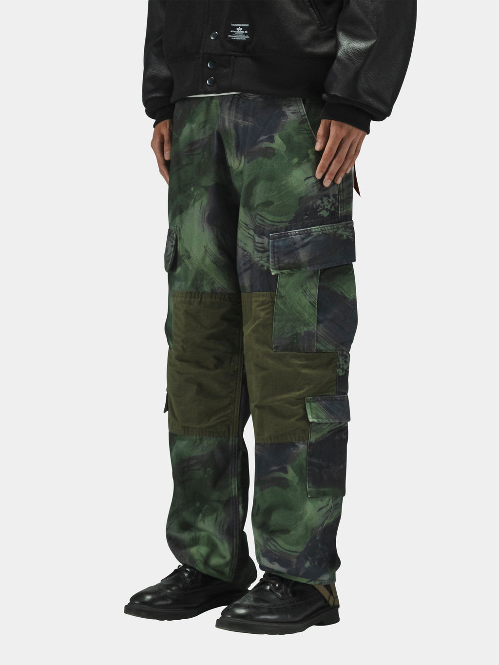 Alpha Industries Acu Pant in green camouflage with black jacket and black shoes.