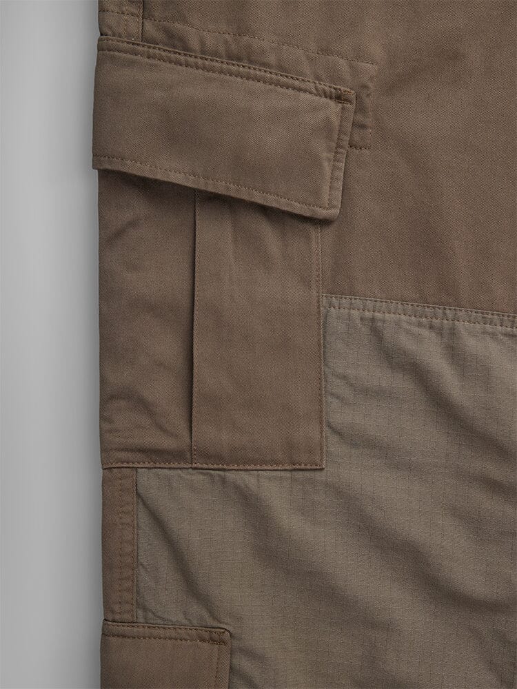 Alpha Industries ACU Pant Coyote Brown, brown and olive patchwork fabric, visible stitching, rectangular flap detail, utility pocket accents.