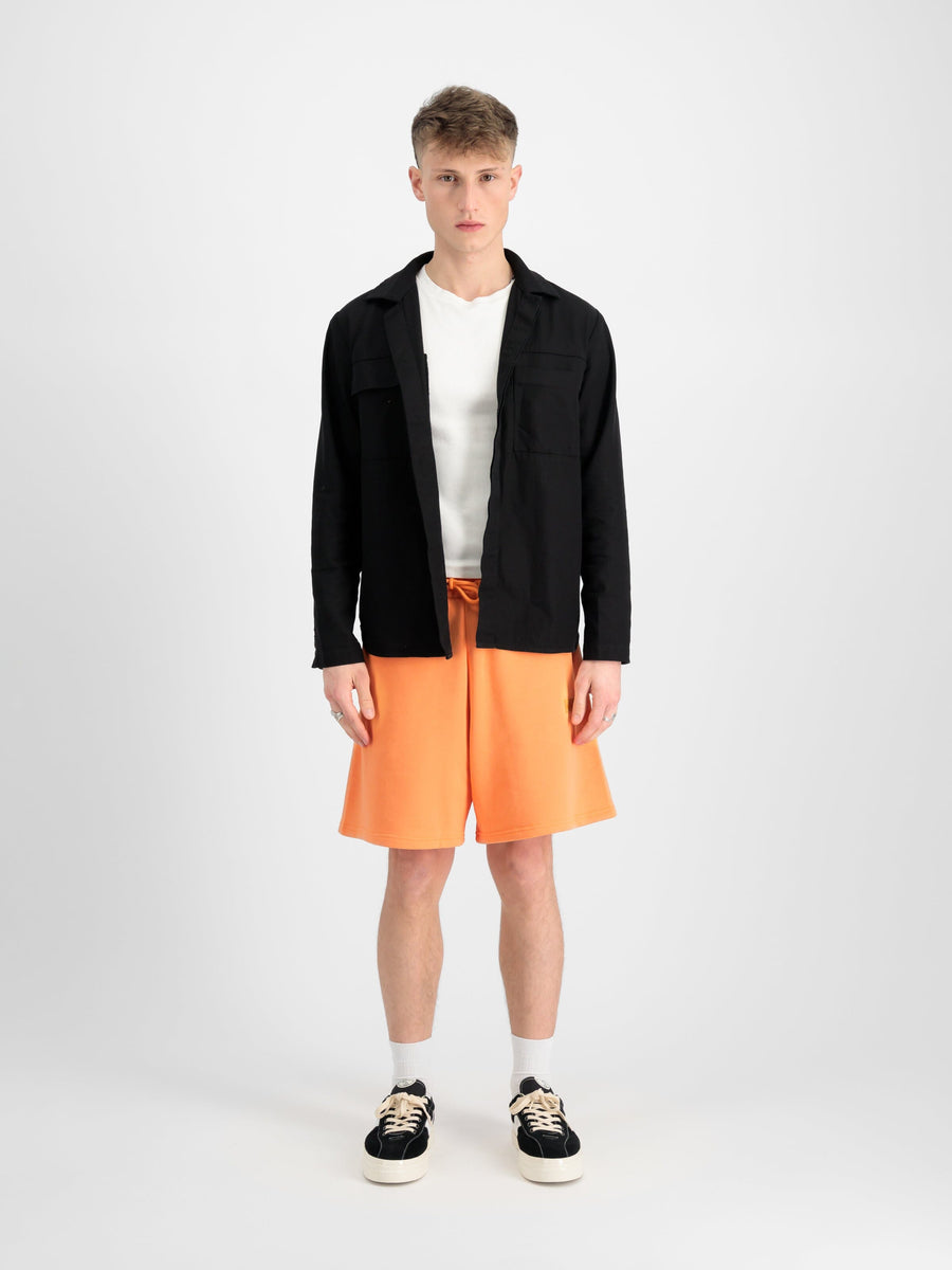Alpha Industries Alpha Essential Relaxed Short in orange with elastic waistband and drawstring closure.