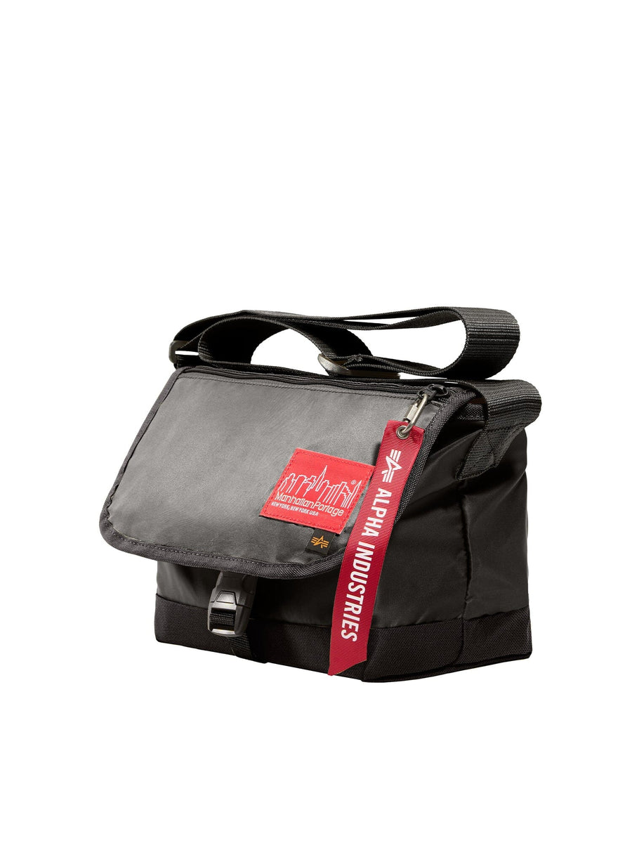 Alpha X Manhattan Portage Nylon Messenger Bag Sm by Alpha Industries, black flight nylon bag with flap closure, red label patch, red zipper keychain, high-vis rescue orange accents.