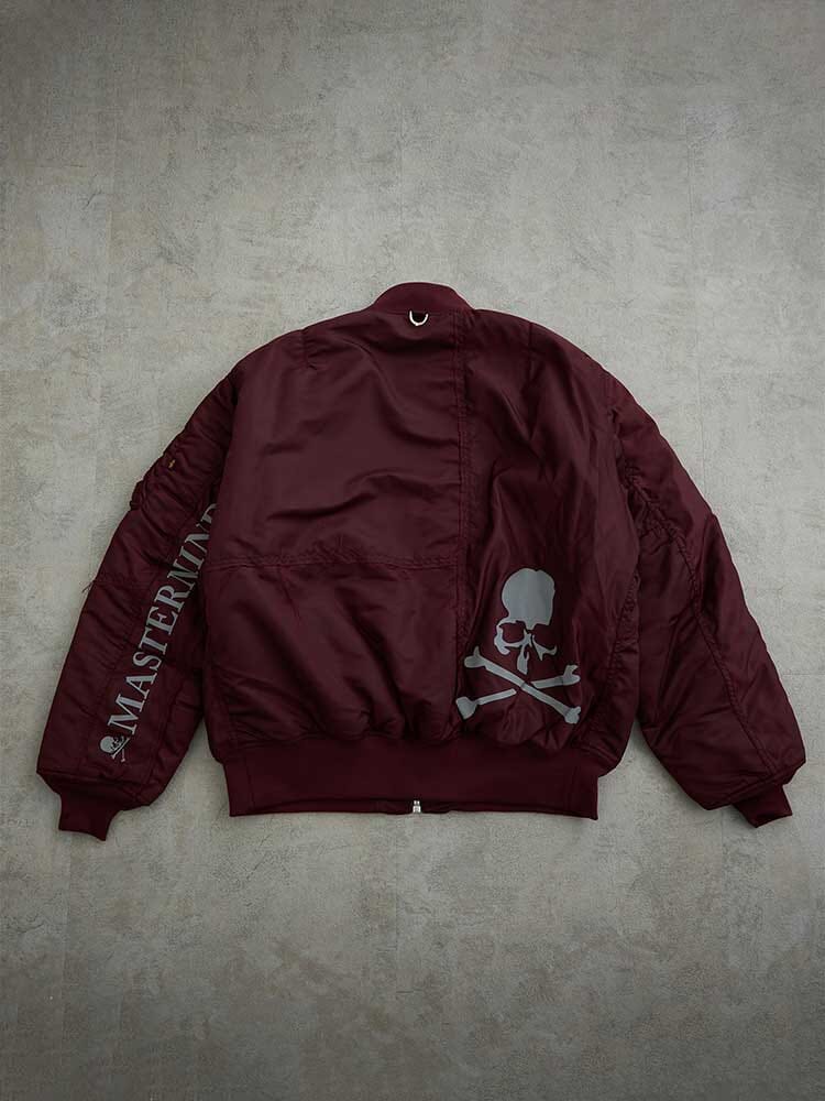 Alpha Industries MA-1 Bomber Jacket, maroon color, skull and crossbones graphic on back, Mastermind on sleeve.