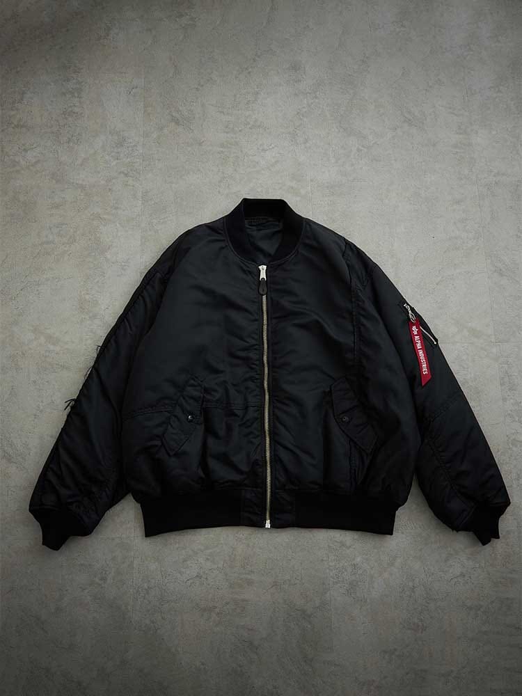 Alpha Industries MA-1 Bomber Jacket in Black with Front Zipper, Ribbed Collar, Cuffs and Hem, Zippered Arm Pocket with Red Tag, Made in Japan.