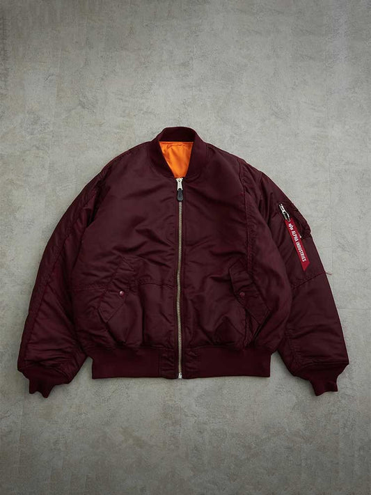 Alpha Industries MA-1 Bomber Jacket in Burgundy with Orange Lining, Front Zipper, Two Side Pockets, and Zippered Sleeve Pocket.