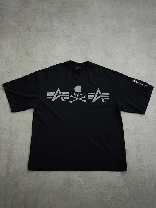 Alpha X Mastermind Tee by Alpha Industries in Black, chest skull and crossbones graphic, stylized lines, zippered left sleeve pocket.