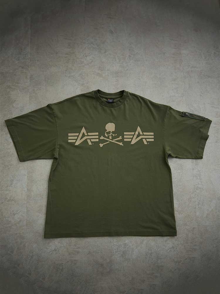 Alpha X Mastermind Tee by Alpha Industries in Olive, features skull and crossbones with arrow graphics, made in Japan.