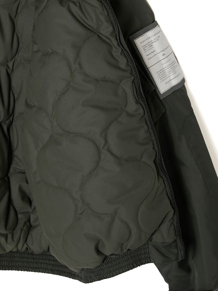 A close-up of the interior of the Alpha X N. Hoolywood CWU-45P w/ Detachable Hood in green reveals the signature label and textured padding, reminiscent of an Alpha Industries flight jacket.