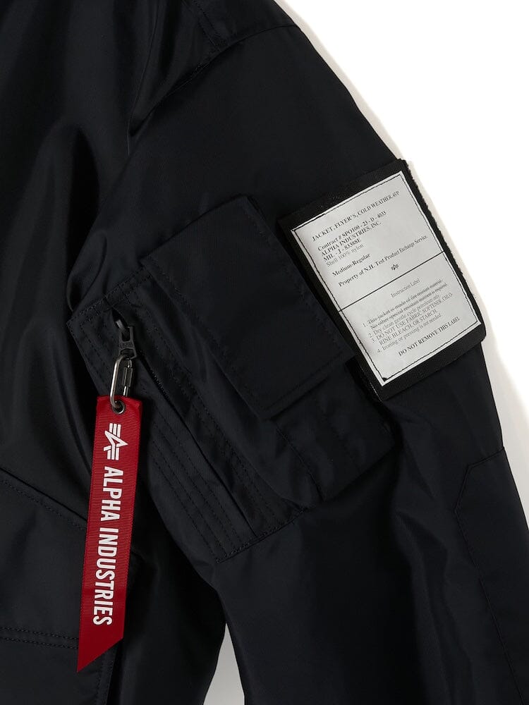 Close-up of a sleeve from the Alpha X N. Hoolywood CWU-45P W/ Detachable Hood flight jacket, featuring a zippered pocket, a patch, and the distinctive red Alpha Industries tag.