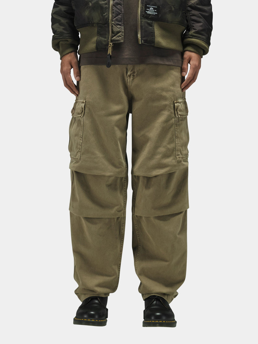 Alpha Industries Bdu Cargo Pant with side pockets, black shoes, dark camo jacket.