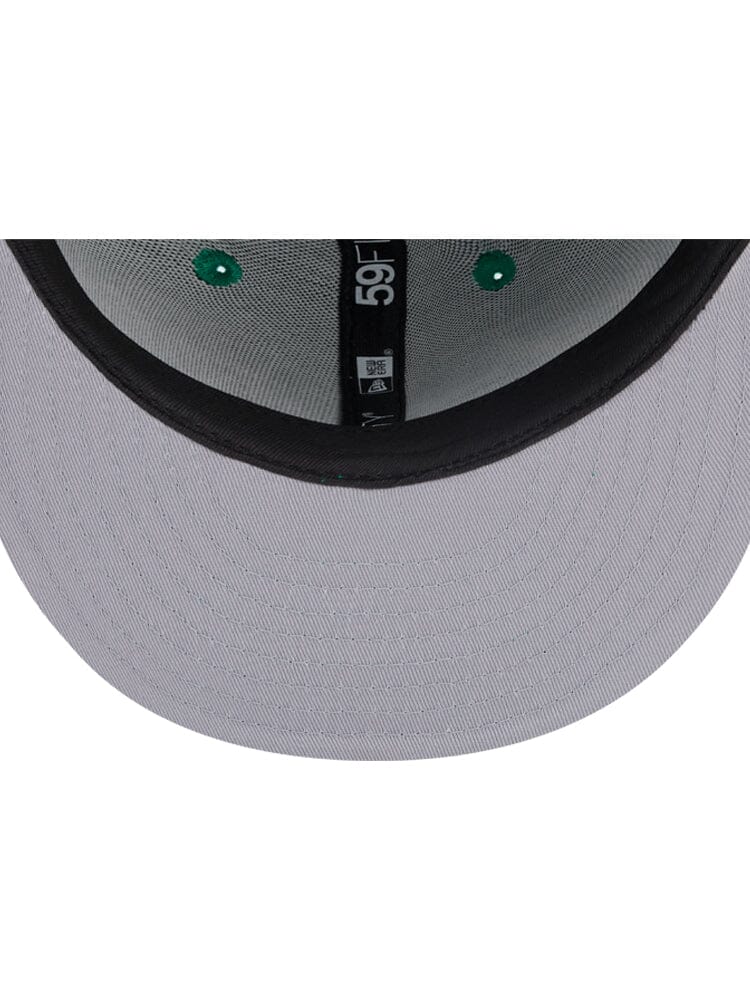 Close-up of the underside of a Boston Celtics x Alpha Industries x New Era 59Fifty Fitted Cap, showcasing its distinct design with a black band, green accents, and an embroidered team logo.