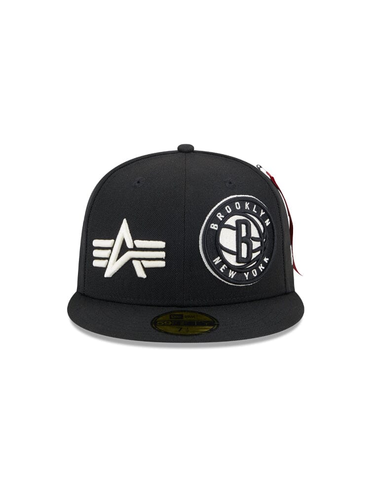 The Brooklyn Nets x Alpha x New Era 59Fifty Fitted Cap, by Alpha Industries and NE-NBA, features a sleek black design with embroidered logos: a stylized 'A' for Alpha Industries on the left, and 'Brooklyn New York' with a central 'B' on the right, perfectly merging style with team pride.