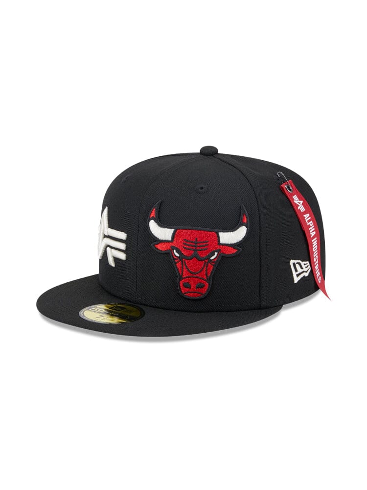 The Chicago Bulls x Alpha x New Era 59Fifty Fitted Cap is a black cap showcasing an embroidered team logo of a red bull and sleek white letters. It features a signature red tag on the side, perfectly aligning with the team's colors. This stylish piece is presented in collaboration with Alpha Industries® and NE-NBA.