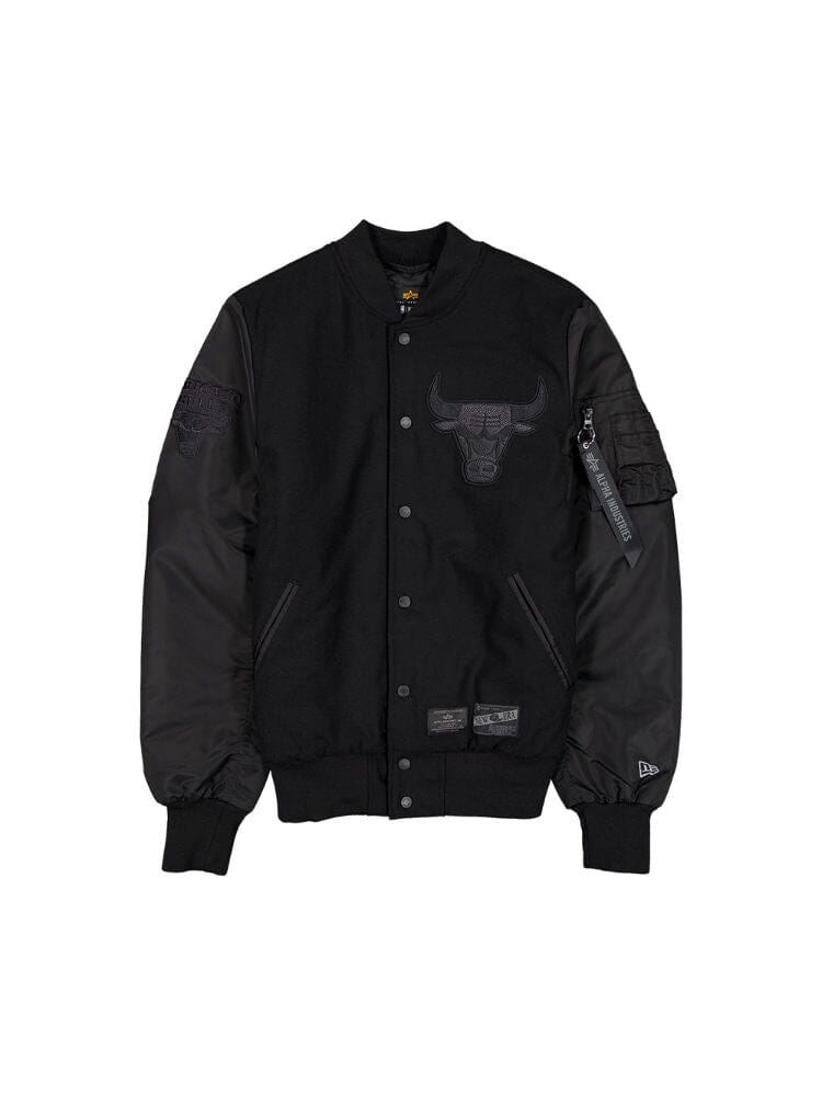 Black varsity jacket with leather sleeves, showcasing the Chicago Bulls emblem on the chest and sleeve. It features snap button closure and a zippered arm pocket. Brand tags for Alpha Industries can be found at the bottom.