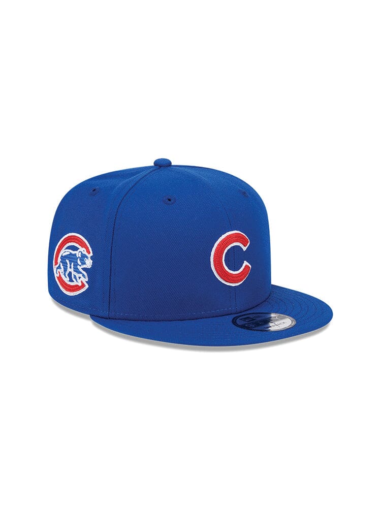 Introducing the Chicago Cubs x Alpha x New Era 950 Cap from Alpha Industries, this blue baseball cap proudly displays the Chicago Cubs team logo on both the front and side. It features a comfortable snapback closure and is a stylish collaboration between New Era® and Alpha Industries®.