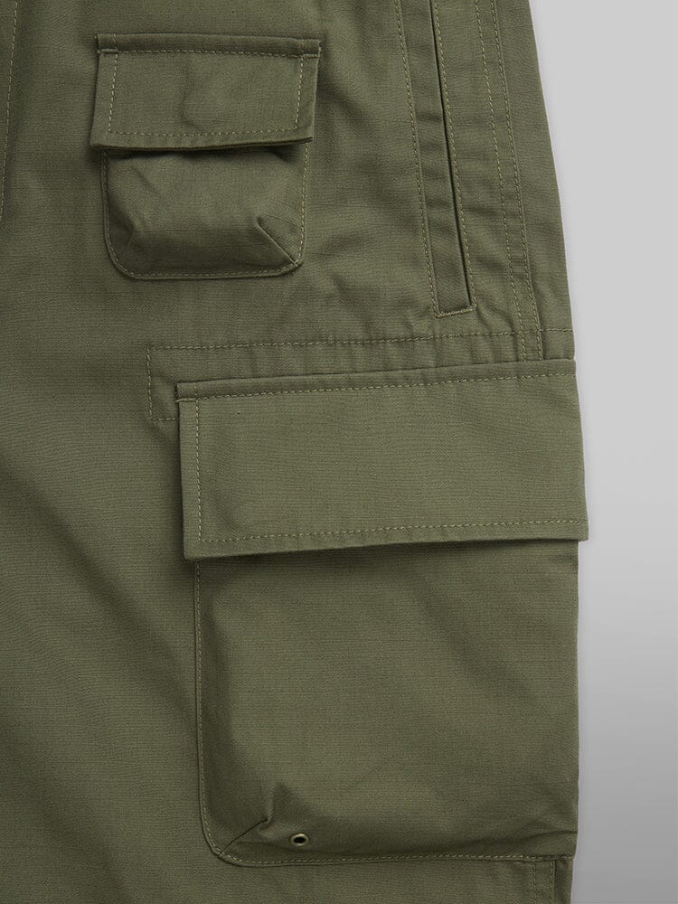 Alpha Industries Convertible Cargo Pant in OG-107 Green, with Two Flap Pockets, Button Closures, and Stitched Details.