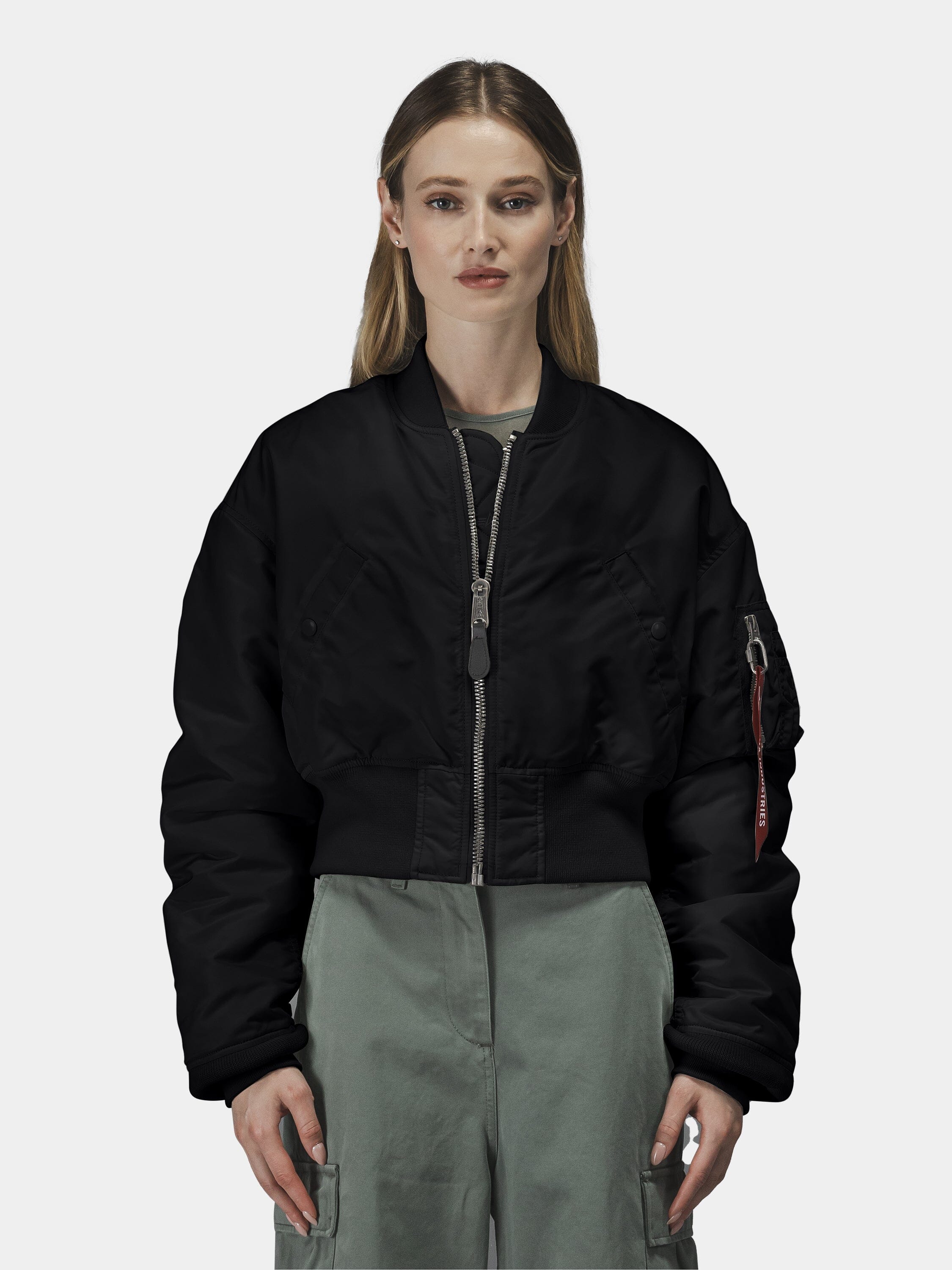 Alpha Industries Cropped MA-1 Flight Jacket Womens in black with front zipper, worn over a green outfit.