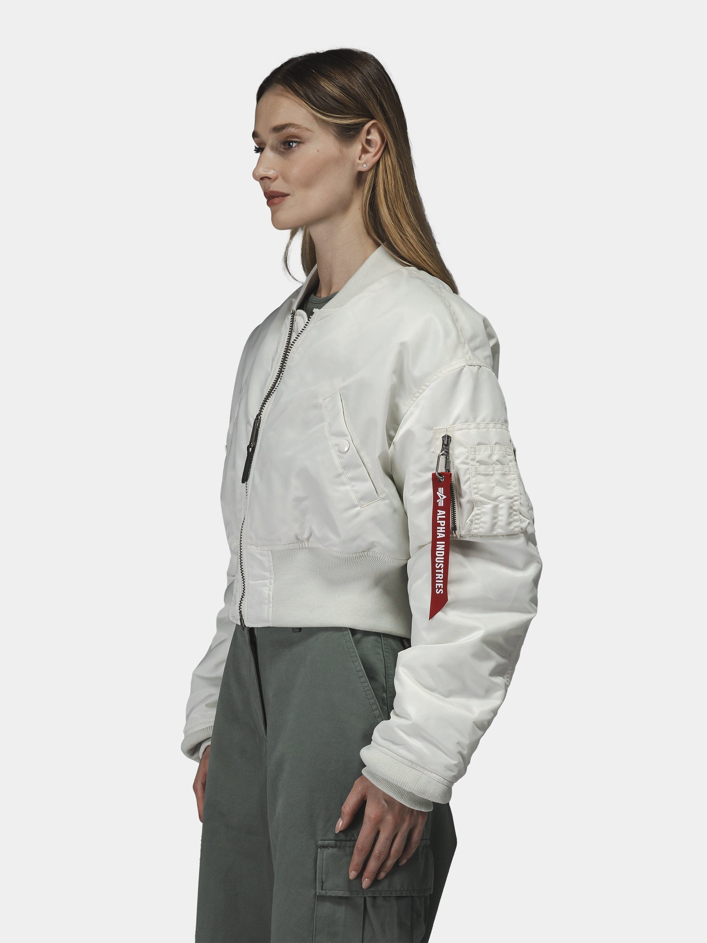 Alpha Industries Cropped MA-1 Flight Jacket Womens with red sleeve tag, paired with green cargo pants.