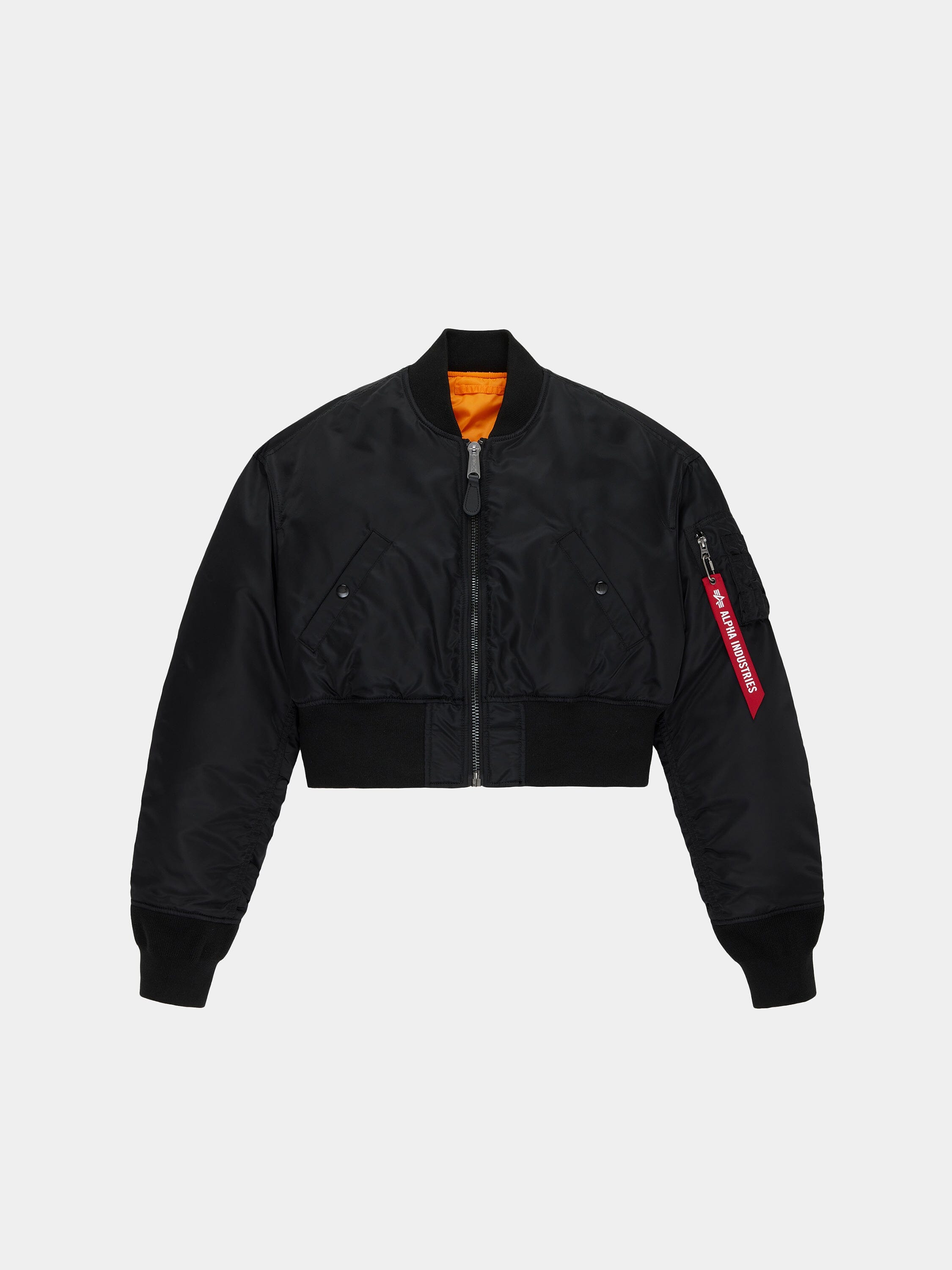 Alpha Industries Cropped MA-1 Flight Jacket Womens in black with front zipper, ribbed cuffs and hem, angled pockets, red sleeve tag, orange lining.