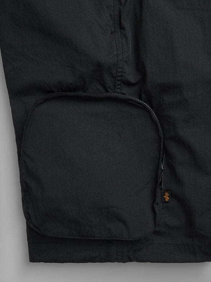 Alpha Industries Cwu 36/P Pull On Short, black, large rounded zippered cargo pocket, small orange and black tag near zipper.