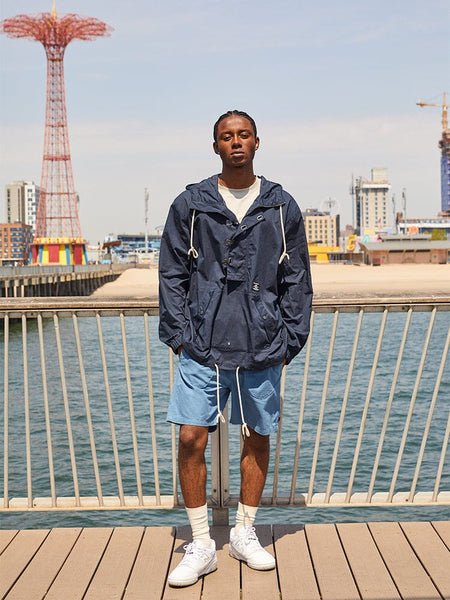 Alpha Industries Deck Shorts, navy jacket, white socks, sneakers.