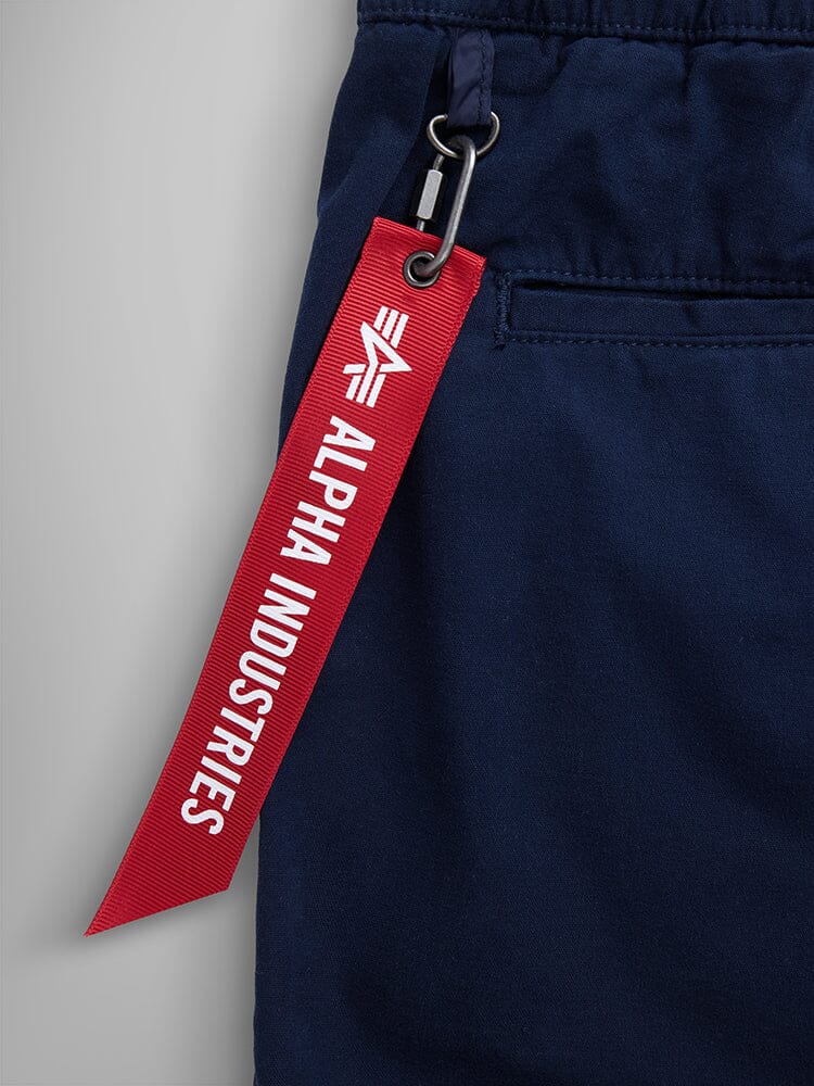 Alpha Industries Deck Shorts, Navy Blue, Breathable Fabric, Red Keychain with White Text.