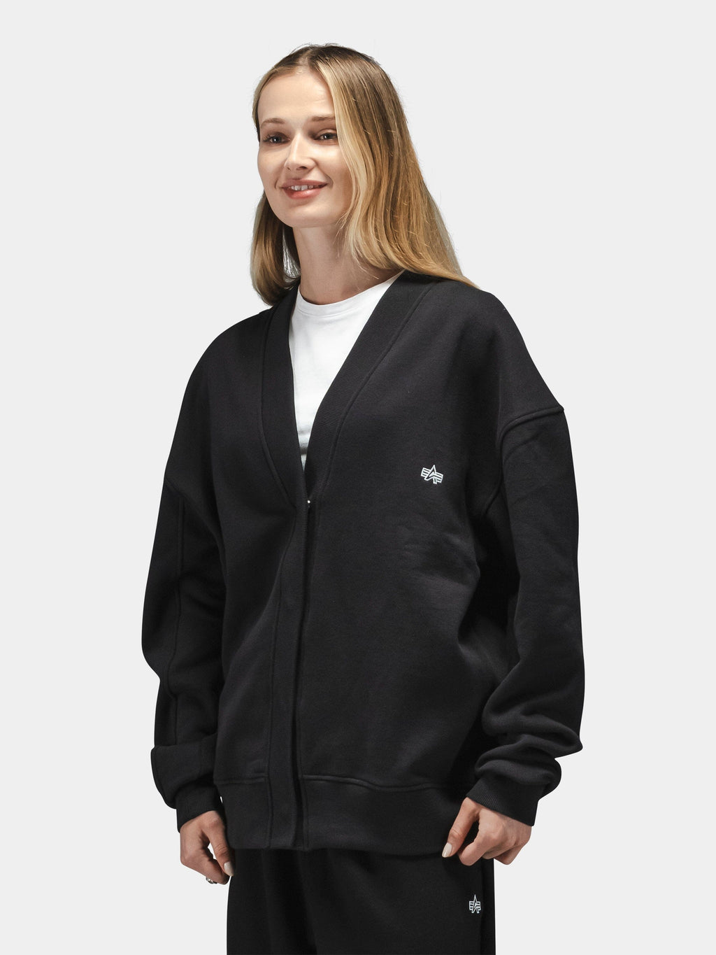 Alpha Industries Essential Cardigan in cotton-poly blend, black, worn over white t-shirt and black pants.