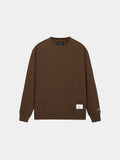 Alpha Industries Essential Crewneck in Espresso with long sleeves, ribbed cuffs and hem, logo on left sleeve, white tag near hem.