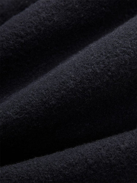 Close-Up of the black fleece material from the Women's Essential Sweatpants by Alpha Industries, showcasing a visible texture and inviting folds that recall cozy comfort.