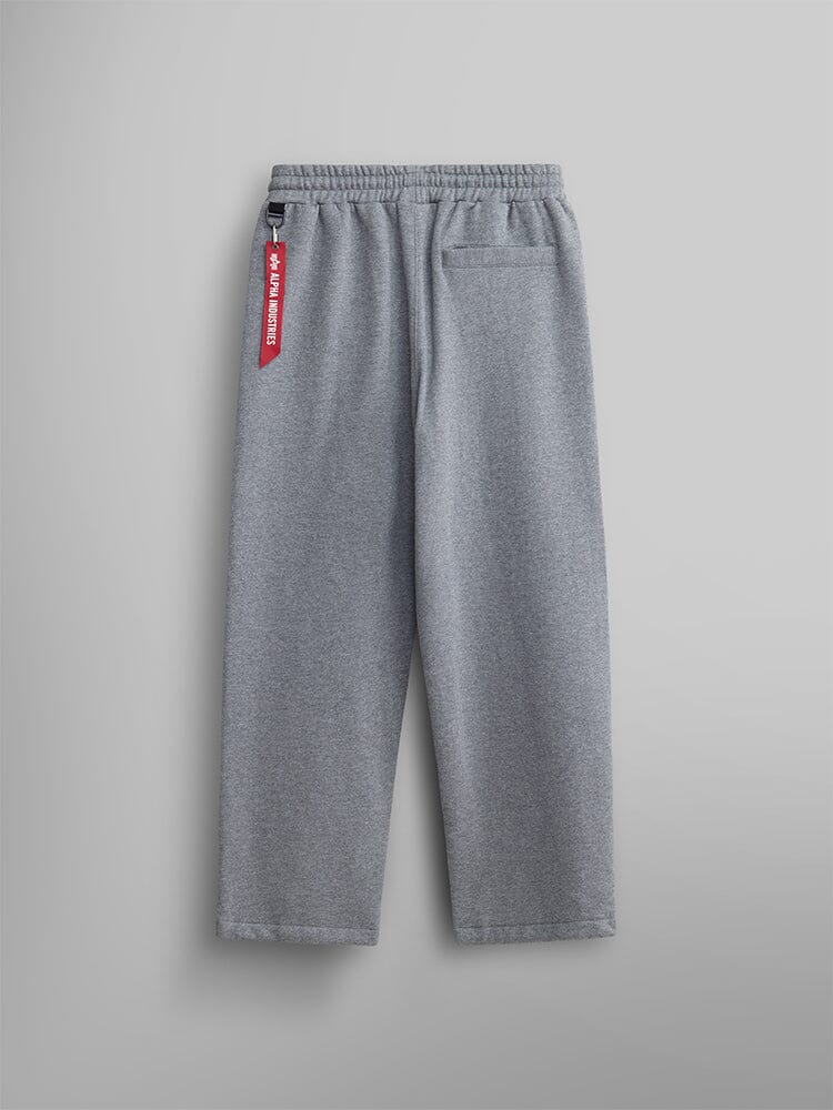 Back view of the gray Women's Essential Sweatpants from Alpha Industries. Made from soft cotton fabric, featuring an elastic waistband and a chic red tag on the side.