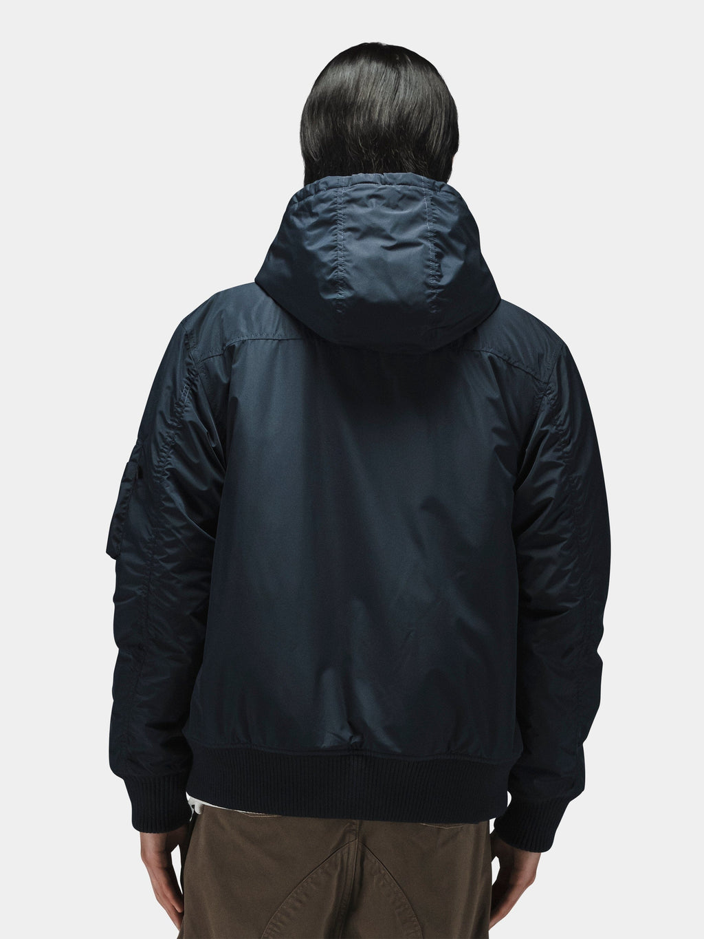 Alpha Industries Hooded Rib Flight Jacket with utility sleeve pocket and brown pants.