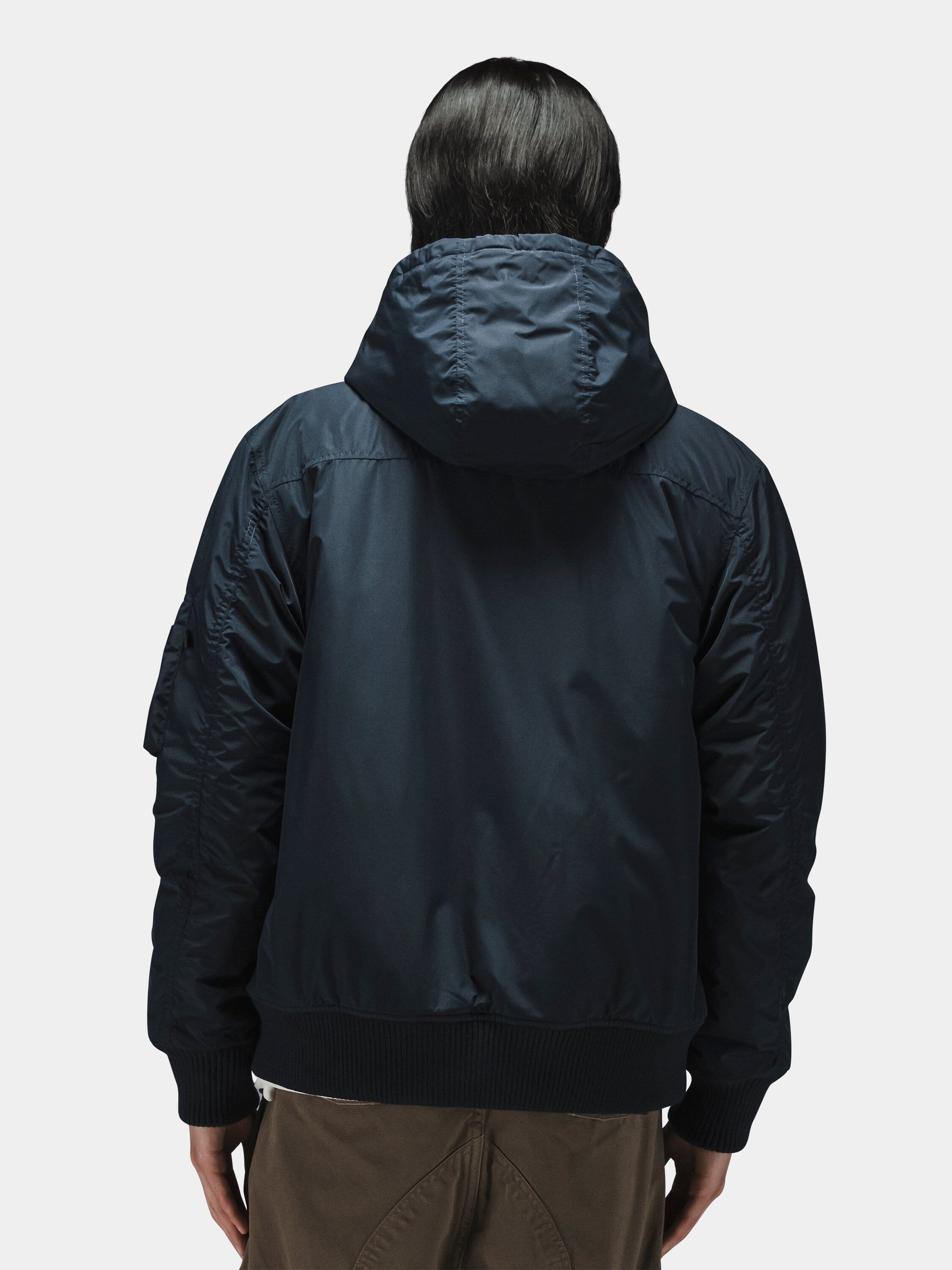 Alpha Industries Hooded Rib Flight Jacket with utility sleeve pocket and brown pants.