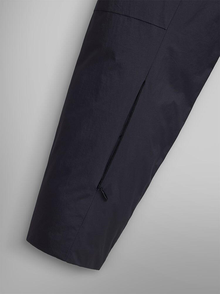 Close-up of the water-resistant black sleeve with a hidden zipper pocket on a fabric surface, embodying the streetwear essence of the Insulated Shirt Jacket by Alpha Industries.
