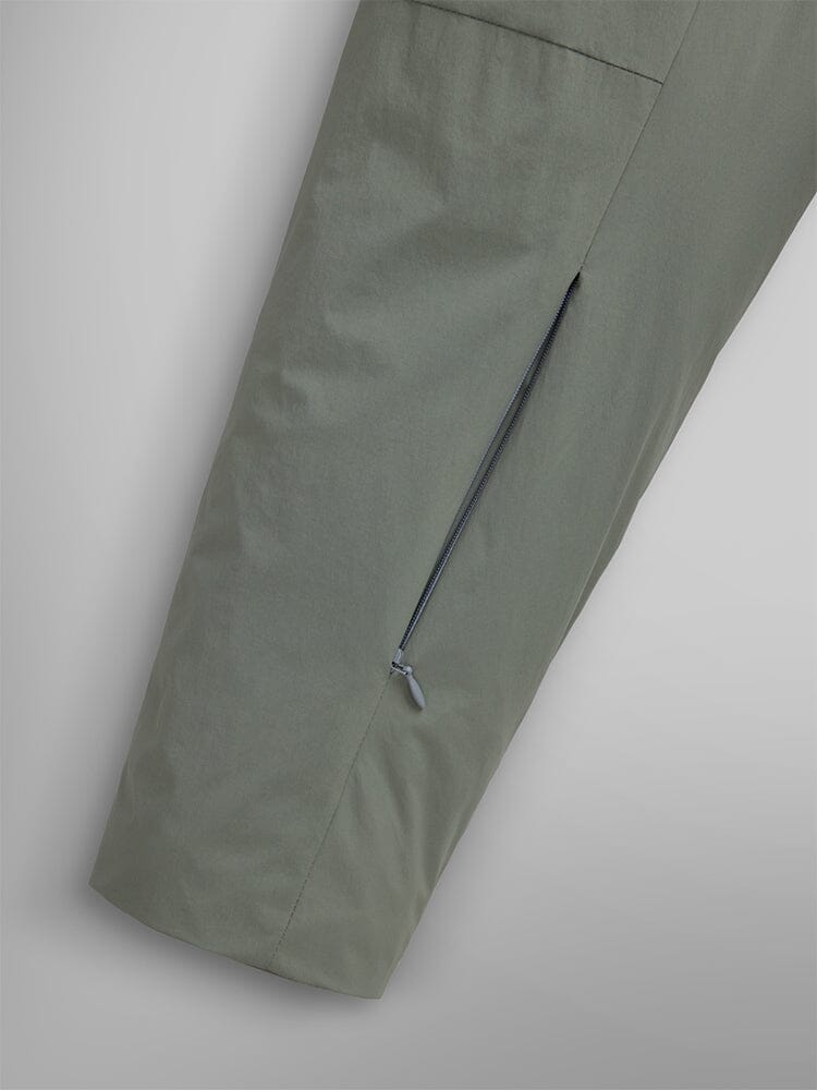 Close-up shot featuring a green insulated shirt jacket from Alpha Industries, highlighting its diagonal zipper pocket for a streetwear vibe.