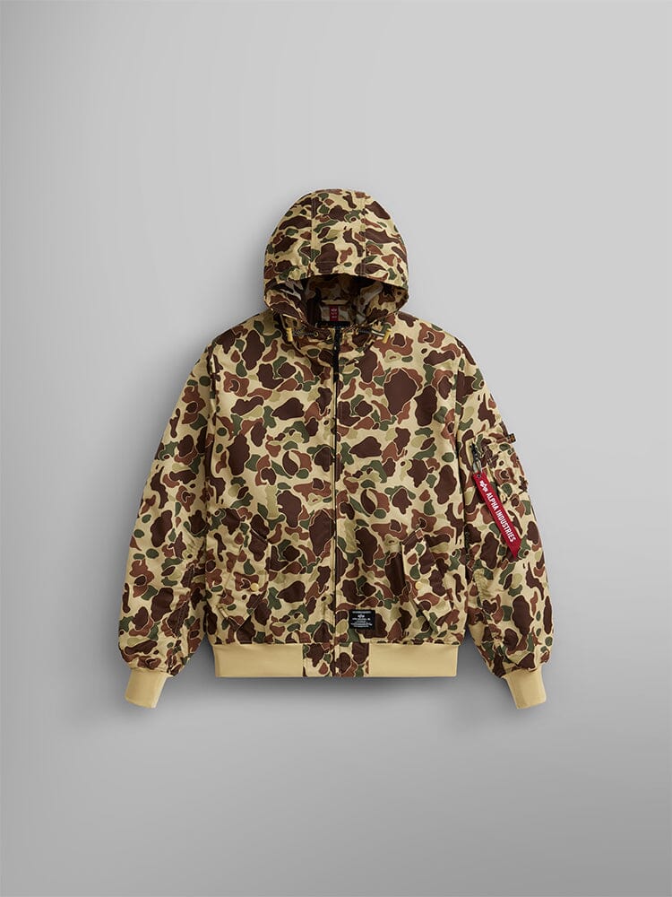 Alpha Industries, Inc.'s L-2B Hooded Gen II Bomber Jacket in Green Frogskin Camo is a nylon flight jacket with a hood, featuring ribbed cuffs and hem, and a red tag on the sleeve.