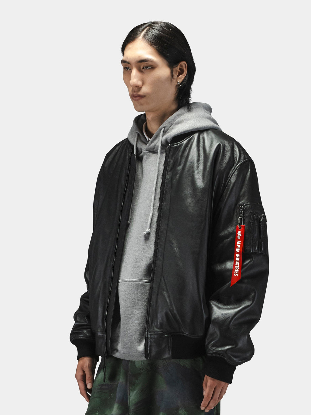 Alpha Industries Leather MA-1 Flight Jacket, black leather, worn over gray hoodie and green patterned pants.