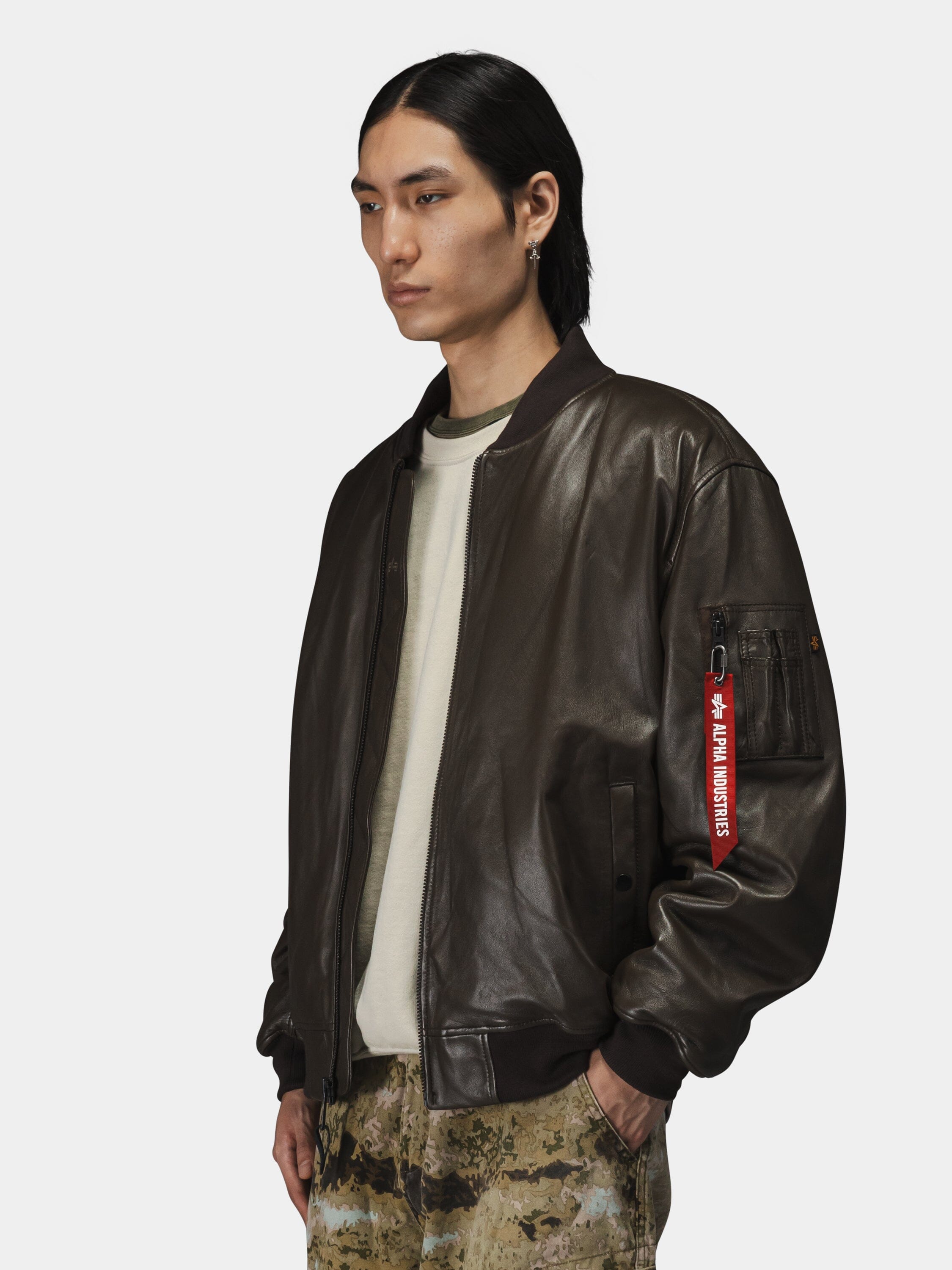 Alpha Industries Leather MA-1 Flight Jacket in dark brown, leather material, zip closure.